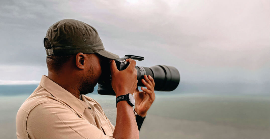 Guide using binoculars against a cloudy sky on Ol Pejeta Conservancy Kenya safaris