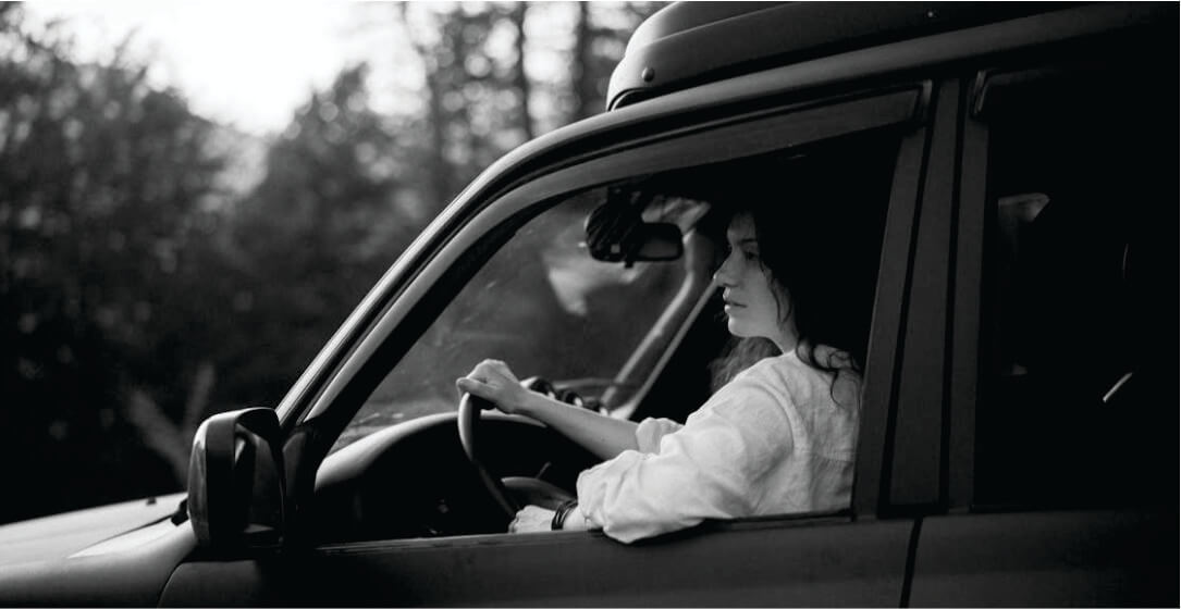 Woman driving a car with a scenic background