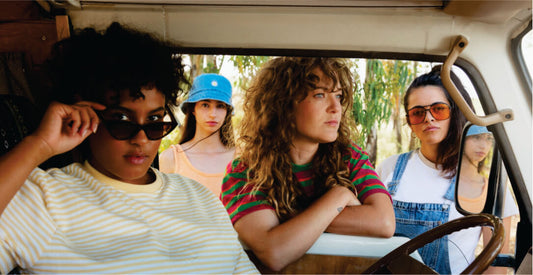 Four women sitting inside a transfer vehicle with a scenic background